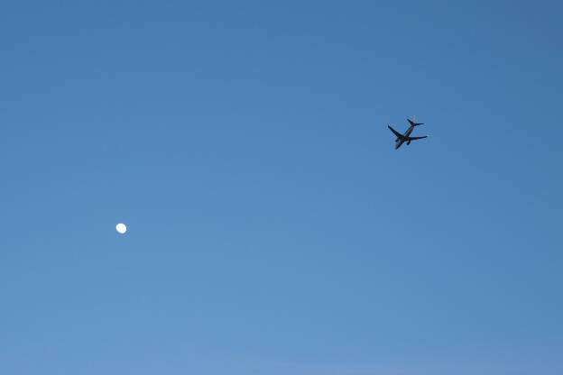 Flugzeug vor blauem Himmel und Mond