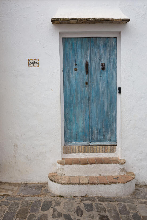 weiße Wand mit blauer Holztür