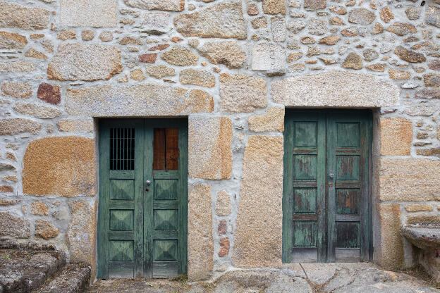 Steinmauer mit grünen Türen