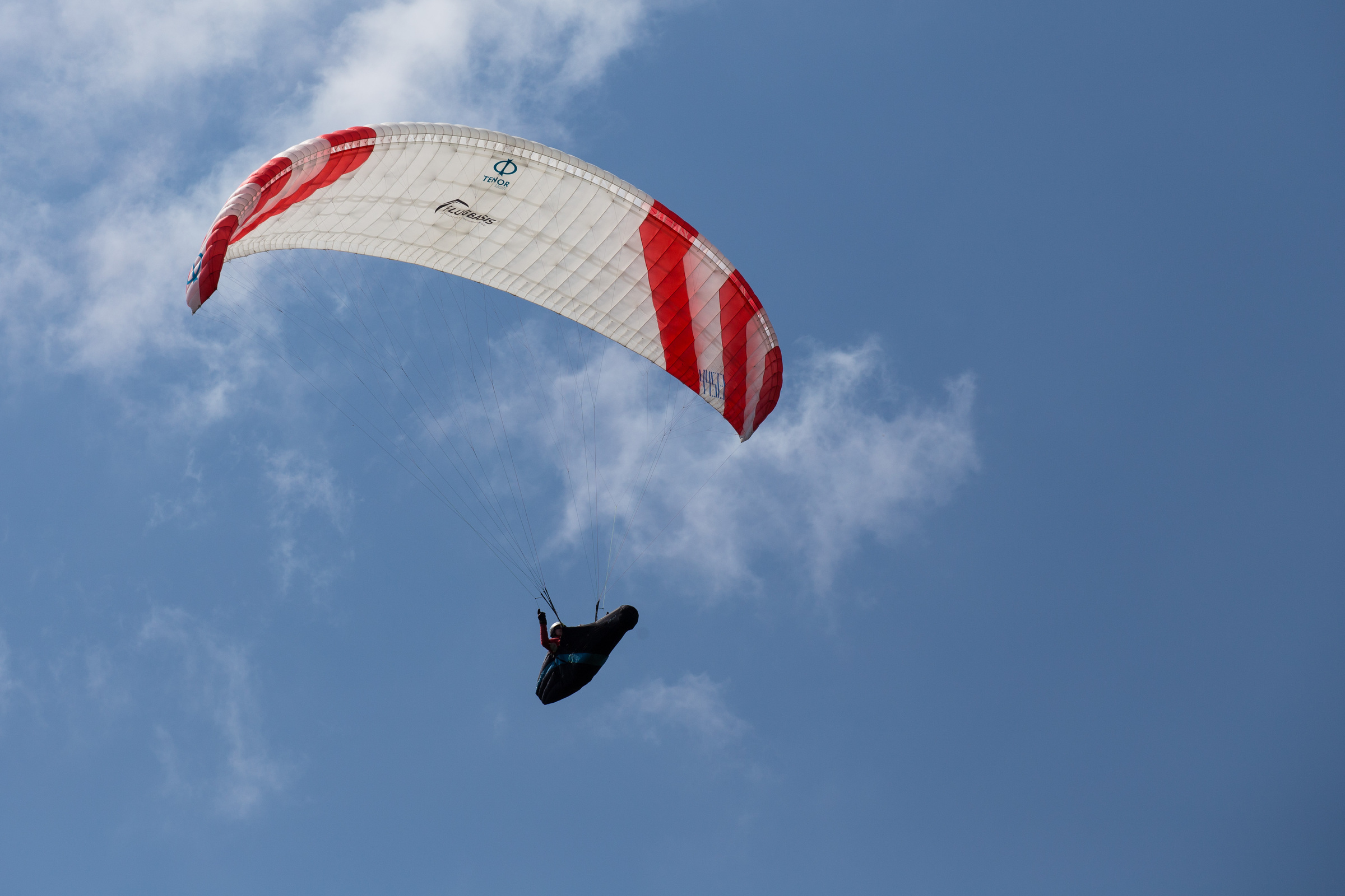 Gleitschirmflieger vor Wolken im Himmel