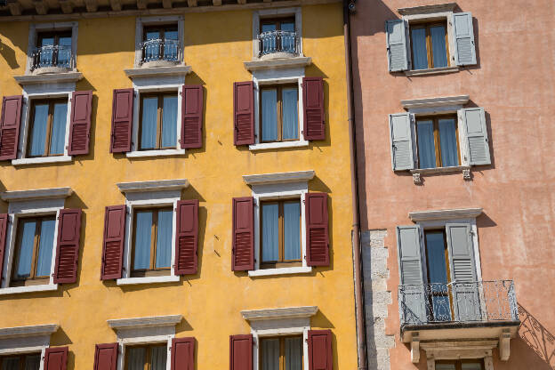 Hauswand mit offenen Fensterläden in Riva del Garda